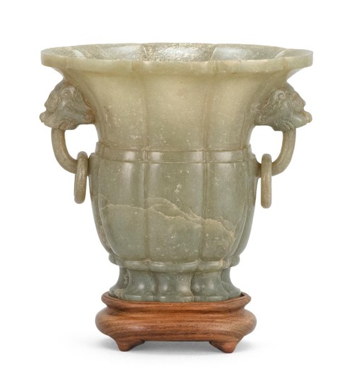 CHINESE CELADON JADE VASE In trumpet form, with melon ribbing and lion's-head loose ring handles. Height 5".