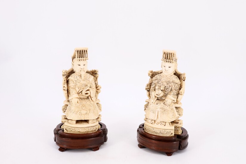 Deux sujets en ivoire dits ''couple impérial'', figurant un homme et une femme assis en...