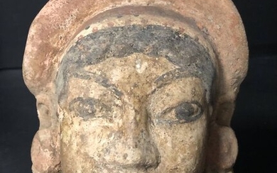 Etruscan Polychromed terracotta antefixe element depicting a female face, 17 x 14 cm
