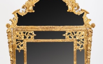 Important miroir à fronton et parecloses en bois sculpté et doré à décor de coquilles...