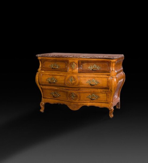Moulded and carved walnut chest of drawers, the lively front opening with four drawers in three rows, the curved uprights resting on small arched legs joined by a scalloped apron; top of red marble of Rance (repaired and associated).