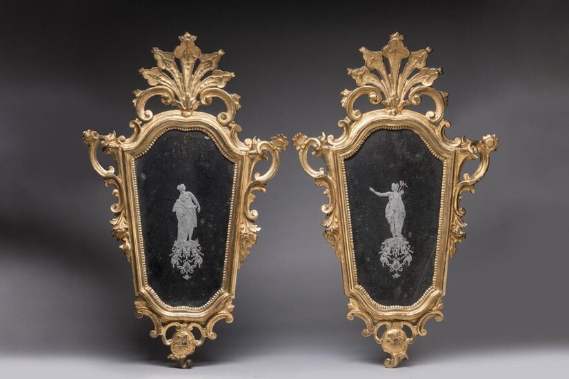 PAIR OF MIRRORS with VENUS and DIANE in an eventful shape, in a gilded wooden Rococo frame with motifs of blooming flowers and interlacing; the mirrors decorated in the centre with Venus for one, Diana for the other in agglomerated glass. Probably...
