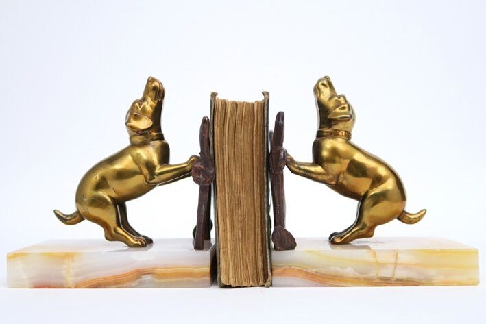 Paire de bibliothèques Art Déco françaises avec chacune une sculpture de chien doré sur sa...