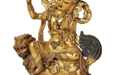 Property of a Gentleman (lots 36-85) A Sino-Tibetan gilt-bronze figure of Green Tara on a Buddhist lion, 18th/19th century, Tara cast seated in lalitasana wearing a five-peaked crown set with turquoise cabochons with her right hand held aloft...