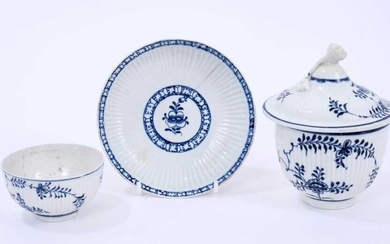 Three Lowestoft pieces, all ribbed, including a sucrier and cover, with flower finial, painted in blue the 'Immortelle' pattern, crossed swords mark, 23cm high, a tea bowl painted in the same patte...
