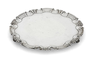 Two silver salvers, the larger example London, 1897, William Hutton & Sons, with shaped scroll and piecrust border, the base raised on three scroll feet, 30.5cm dia., the smaller salver with bead and foliate border, Sheffield, 1924, Travis, Wilson...