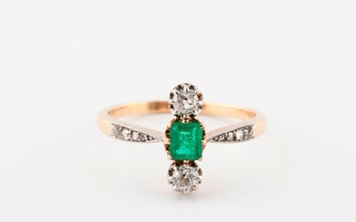 Yellow gold (750) and platinum (850) ring centered on a stepped rectangular emerald framed by two old cut and old brilliant diamonds in claw setting and set with small rose cut diamonds in grain setting.