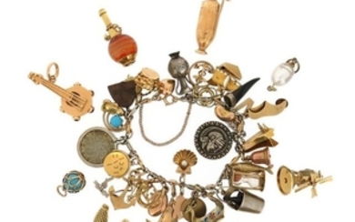 A gold charm bracelet with assorted charms, includ…