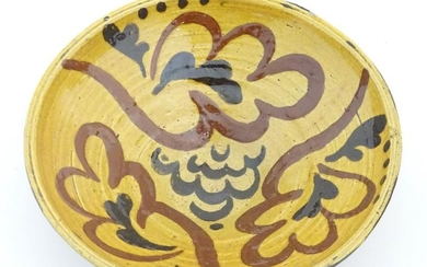 A 19thC slipware bowl with stylised foliate decoration.
