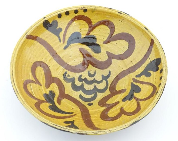 A 19thC slipware bowl with stylised foliate decoration.