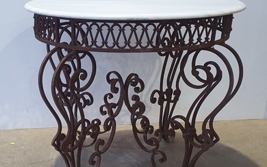 A CIRCULAR WROUGHT IRON BASED MARBLE TOP CENTRE TABLE