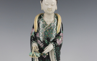 A Chinese famille verte enamelled figure of Guanyin, Qing dynasty, modelled standing wearing a peach