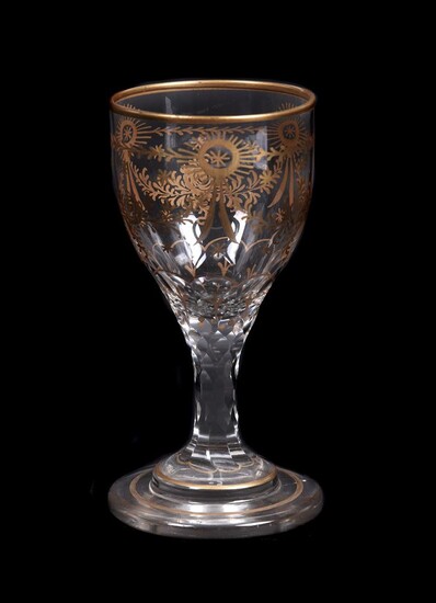 A clear glass and gilt facet-stemmed wine glass
