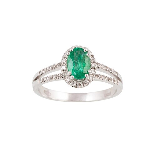 A DIAMOND AND EMERALD CLUSTER RING, the oval emerald to a br...