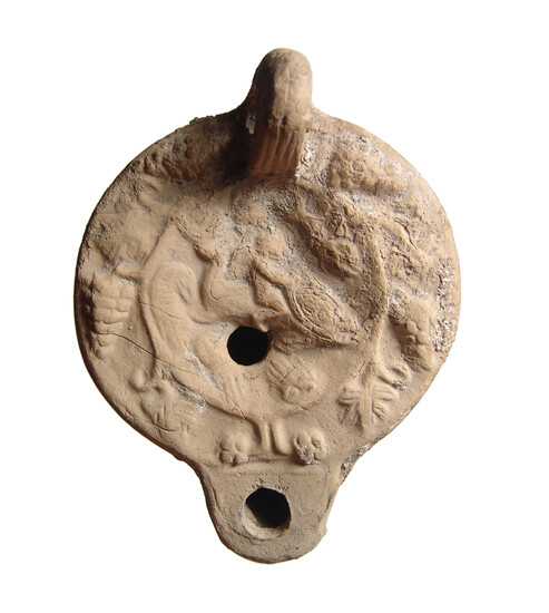 A Roman ceramic lamp with a boy on a dolphin