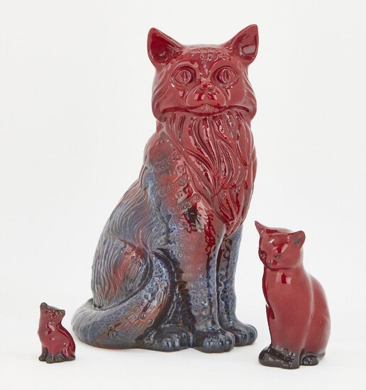 A Royal Doulton flambé figure of a cat, with printed factory mark to base and indistinct impressed registration number, 31cm high, together a smaller Royal Doulton flambé cat, with printed factory marks to base and indistinct registration mark...