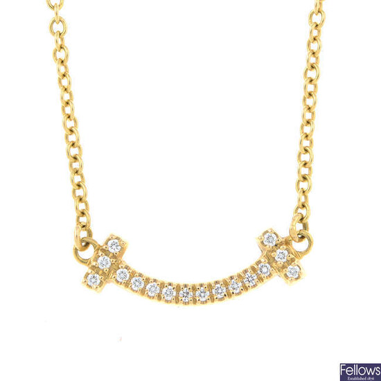 A brilliant-cut diamond 'T Smile' pendant, on an integral trace-link chain, by Tiffany & Co.