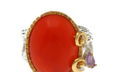 A carnelian ring set with a cabochon carnelian and a pear shaped amethyst, mounted in rhodium plated and partly gilded sterling silver. Size 57.