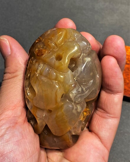 A intricately craved Chinese yellow amber hard stone lion...