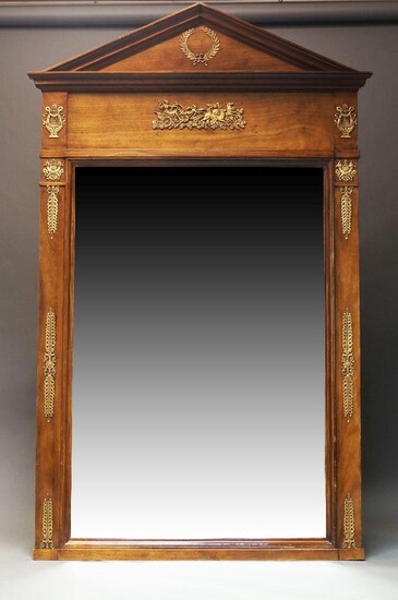 A large French Empire style mahogany and gilt metal mounted mirror, mid 20th Century, with arched pediment centred by gilt metal laurel wreath, above frieze with chariots and horses flanked by lyres, over rectangular plate flanked by Anthemions...