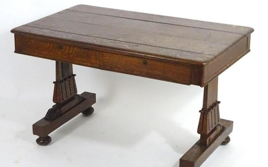 A mid 19thC oak library table with a moulded top above