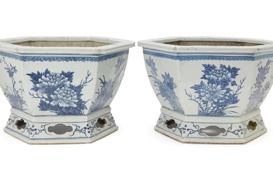 A pair of Chinese hexagonal blue and white jardinières, 19th century, each sturdily potted, moulded with a foliate rim flange and pierced gallery foot speared by curving faceted walls painted with various floral subjects, 37cm diameter. (2) Cf. A...