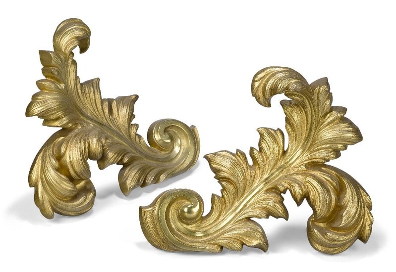 A pair of French gilt-bronze chenets, early 20th century, each in the form of an acanthus leaf, with iron supports, 25cm high, 33cm wide (2)