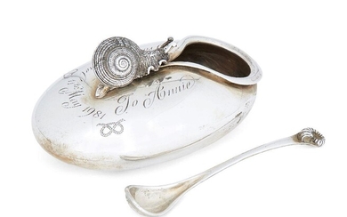 A silver snail salt cellar and spoon by Jocelyn Burton, London, c.1979, of flattened ovoid form, designed with realistically modelled snail surmount and tear-shaped aperture, the spoon (1980) with stylised ammonite terminal, presentation engraving...