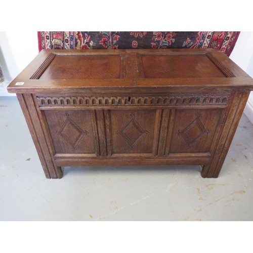 An 18th century oak coffer with a carved three panel front, ...