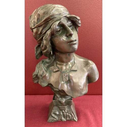 An Art Nouveau style bronze bust of a woman in period dress....