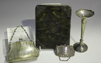 An Edwardian silver mounted green stained crocodile skin wallet of rectangular form, each corner mou