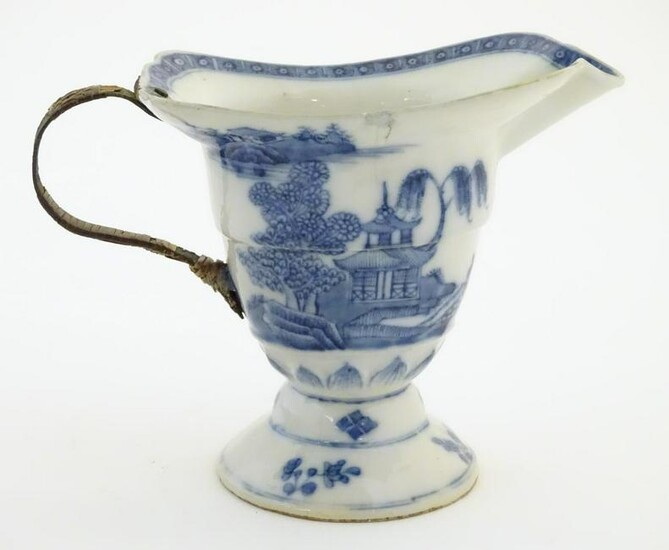 A helmet jug with blue and white decoration with a