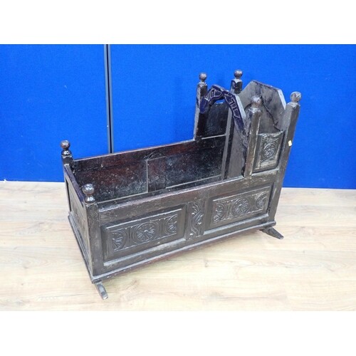 An antique oak Rocking Cradle with carved panels and turned ...