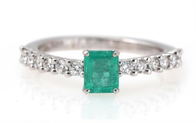 An emerald and diamond ring set with an emerald-cut emerald weighing app....