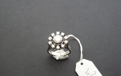 Bague "Fleur" en or gris 18K (750/oo) centrée d'un diamant taille brillant calibrant 0,70 ct...
