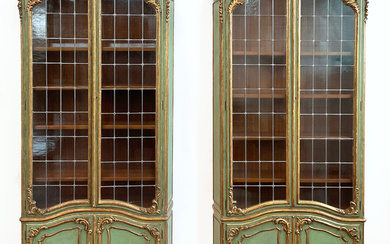Coppia di librerie in stile settecentesco in legno intagliato e laccato verde con profili dorati. Parte inferiore a due ante…