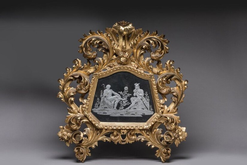 MERCURY MIRROR in carved and gilded wood The frame of the mirror is slightly trapezoidal and animated in the upper part. The engraved mirror presents a mythological scene depicting Mercury. Deep acanthus leaves rolled up and openworked with flowers...