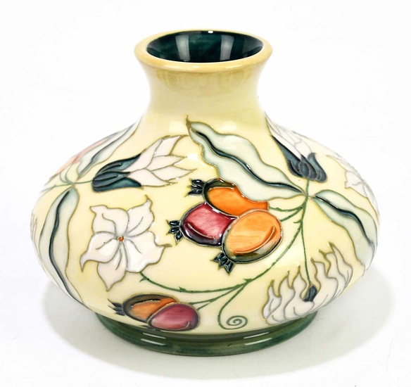 MOORCROFT; a squat vase decorated with floral sprays on an...