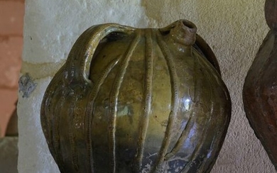 Pink earthenware oil jug with olive green glaze....