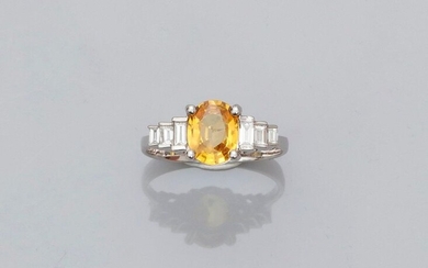 White gold ring, 750 MM, set with an oval yellow sapphire weighing 1.55 carat and set with six stepped baguette-cut diamonds, 17 x 9 mm, size: 55, weight: 3.5gr. rough.