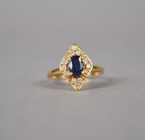 Yellow gold ring in the shape of a flower, decorated in its center with a sapphire surrounded by small diamonds.