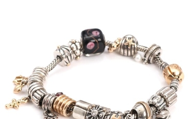 Pandora: A sterling silver and 1k gold charm bracelet. L. 18.5 cm.