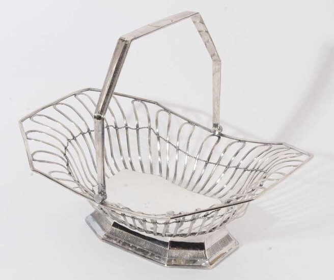 19th century silver plated cake basket of octagonal form with open wire frame and swing handle, raised on flared foot with pierced decoration, apparently unmarked, 34cm in overall length