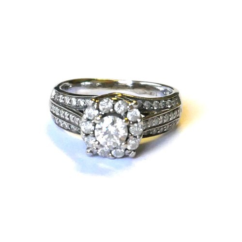 A 14ct WHITE GOLD AND DIAMOND CLUSTER RING Having a central ...