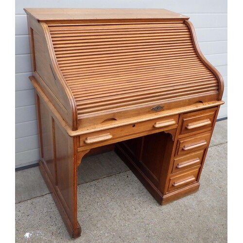 A 1930's walnut roll top, single pedestal desk, missing lock...