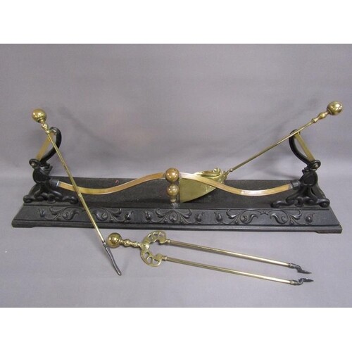 A 19c cast iron and brass fender rail with end tool rests, t...