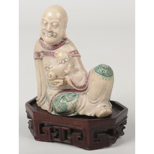 A 19th century Chinese carved soapstone figure raised on a c...