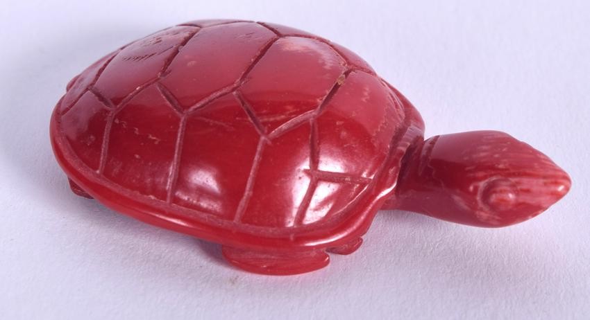 A CHINESE CARVED RED CORAL TORTOISE, formed with its