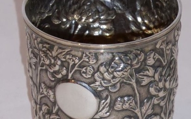 A Chinese silver cylindrical beaker decorated in high relief...