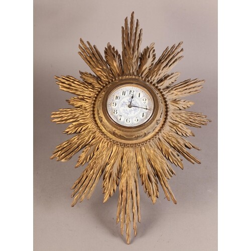 A GILTWOOD STARBURST CLOCK with bead and foliate carved beze...
